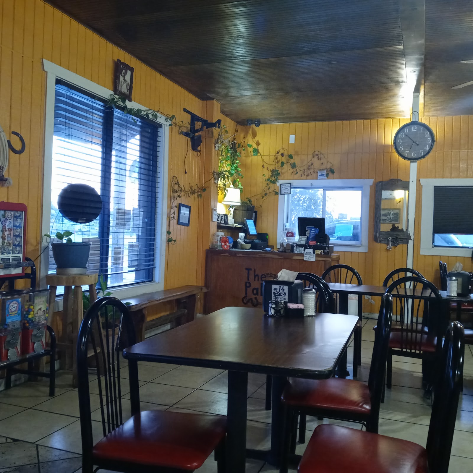 Cozy dining room interior at The Palms Taqueria with wood tables and warm yellow walls